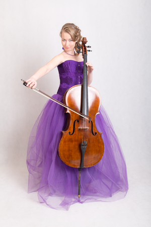 girl in a purple evening dress playing celloの写真素材
