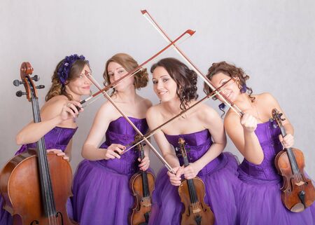musical quartet in evening dresses with strings instrumentsの写真素材