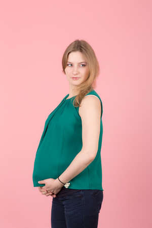 portrait of a pregnant woman on a pink backgroundの写真素材