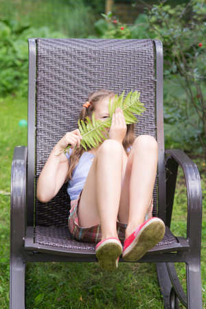 girl sitting in the chair on the grassの写真素材