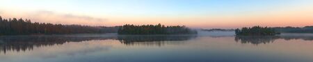 panorama of wood lake with morning fogの写真素材