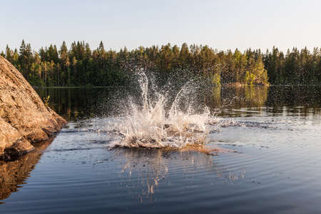Water splashes in a forest lake after the jumpの写真素材