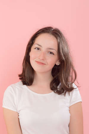 studio portrait of teenage girl on a pink background