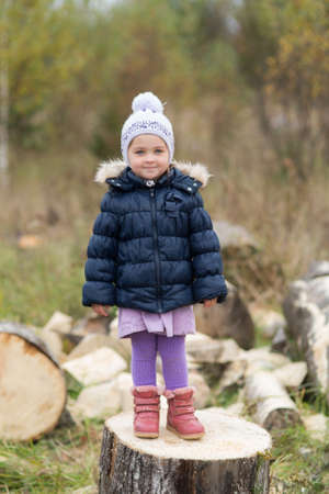 little girl standing on a wooden block of woodの写真素材