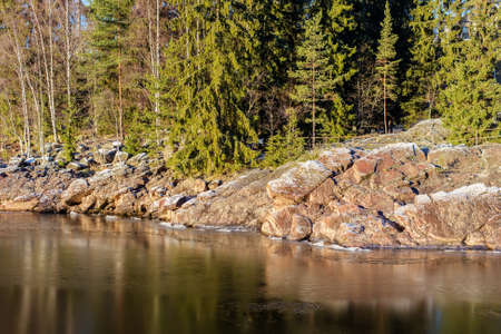 rocky shore of the river and the first snowの写真素材