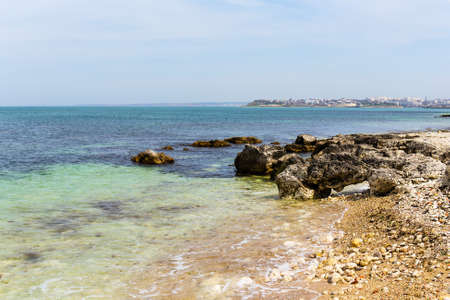 Sea shore with rocks in a sunny dayの写真素材