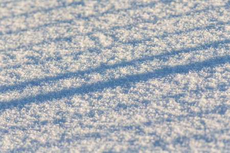 abstract linear shadows on pure snow in winterの写真素材
