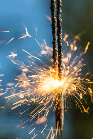 Sparks closeup on a natural blue backgroundの写真素材