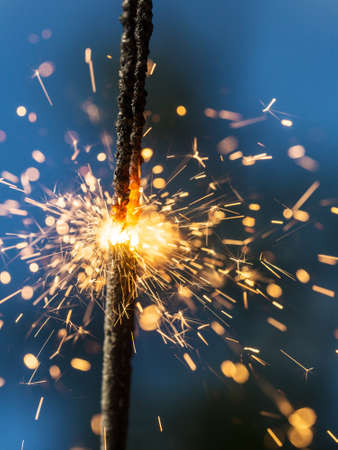 Sparks closeup on a natural blue backgroundの写真素材