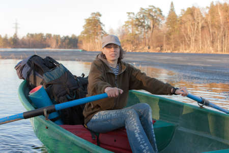 Woman with oars in boat on lake