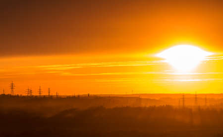 Red sunset over forest and power linesの写真素材