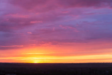 Bright sunset with clouds and the sun on the horizonの写真素材