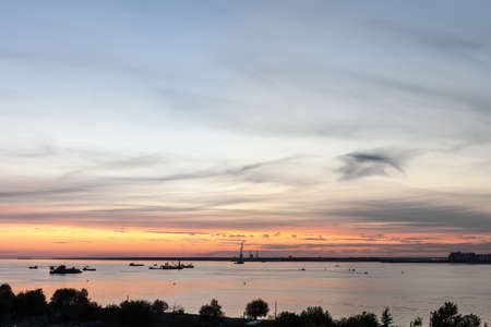 Industrial ships on the bay after sunsetの写真素材