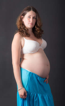 studio portrait of a pregnant woman on a black backgroundの写真素材