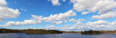 landscape with clouds over the forest lake, panoramaの写真素材