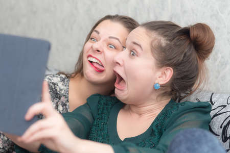 two girls are making faces by shooting selfiesの写真素材