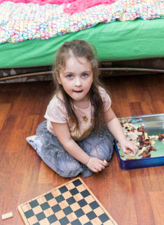 portrait of a little girl studying board games