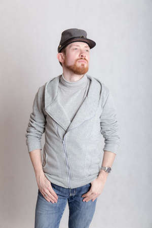 studio portrait of a confident man in a cap