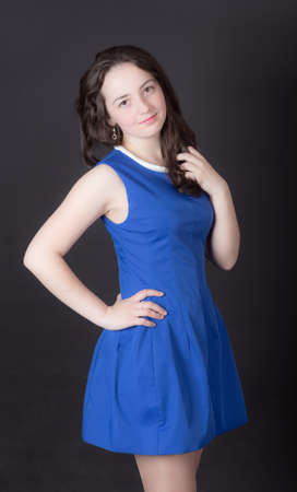 teen girl in a blue dress on a black backgroundの写真素材