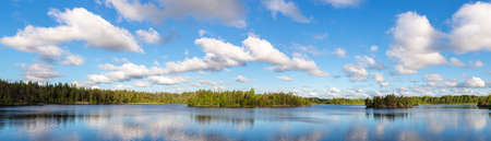 panorama of a forest lake and sky with cloudsの写真素材