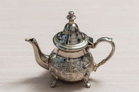 metal kettle on a wooden table close upの写真素材