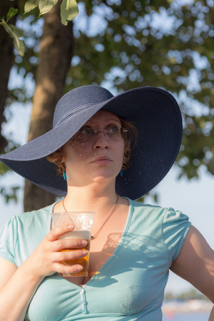 portrait of a woman with a beer on a hot summer dayの写真素材