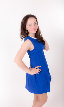 slim teen girl in blue dress on white backgroundの写真素材