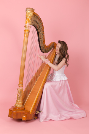 studio portrait of a girl playing the harpの写真素材