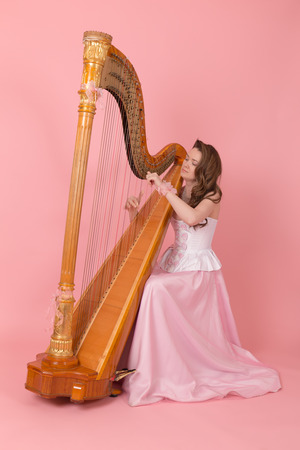 studio portrait of a girl playing the harpの写真素材