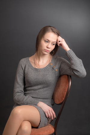studio portrait of a girl on a chairの写真素材