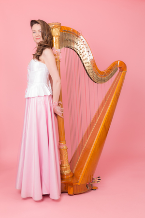 portrait of a girl with a harp on a pink backgroundの写真素材