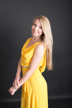 studio portrait of a blonde in a yellow dressの写真素材