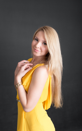 studio portrait of a blonde in a yellow dressの写真素材