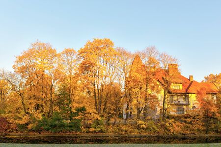 landscape with a house in the autumn park on a sunny dayの写真素材
