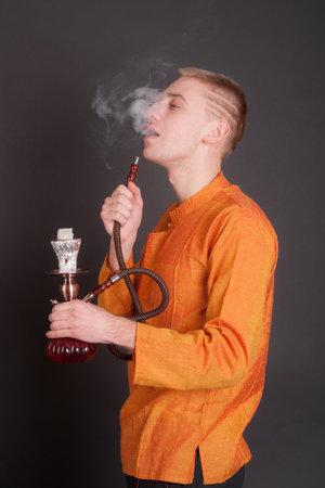 studio portrait of a man with a hookah on a black background