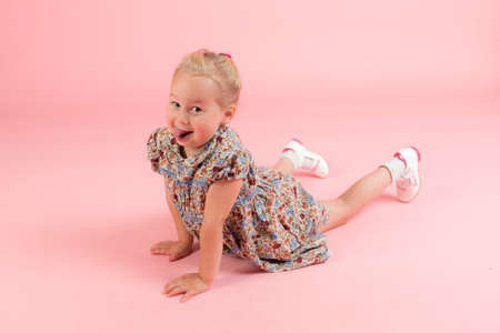 studio portrait of a little girl on a pink backgroundの写真素材