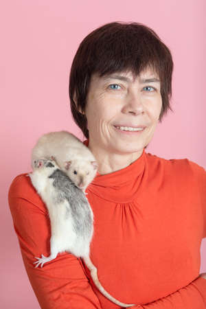 woman with two domestic rats on pink backgroundの写真素材