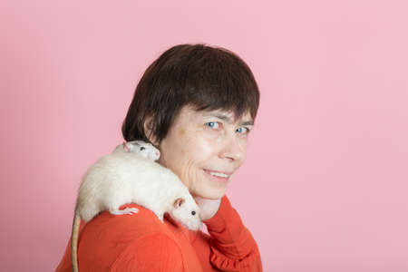 woman with two domestic rats on pink backgroundの写真素材