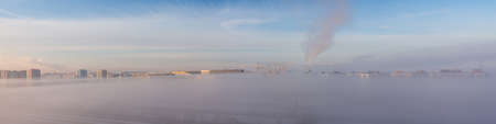 panorama of the city and dense winter fog