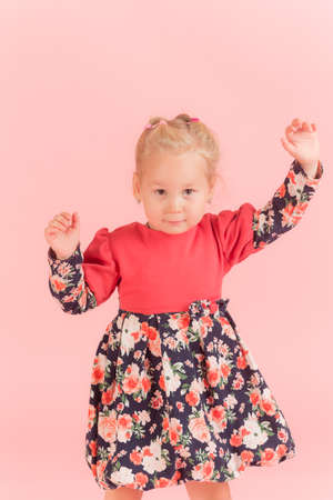 studio portrait of a little girl on a pink backgroundの写真素材