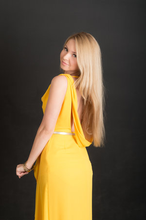 studio portrait of a girl with long hair in a yellow dressの写真素材