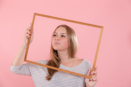 portrait of a girl in a frame on a pink backgroundの写真素材