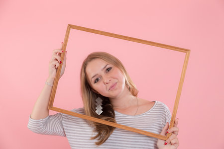 portrait of a girl in a frame on a pink backgroundの写真素材
