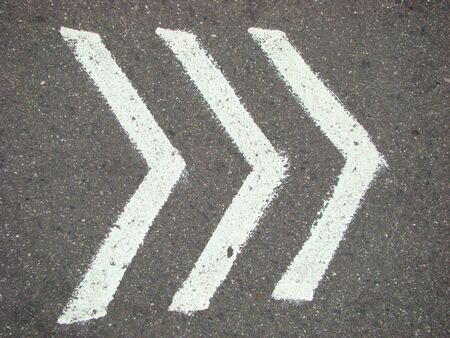 white pointers on an asphalt, indicative direction of motionの写真素材
