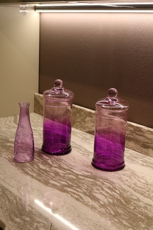 lilac transparent vessels on a marble countertop in the kitchenの写真素材