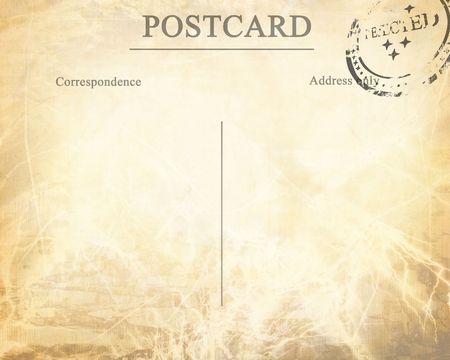 Old post card with a faded postal stamp attached on itの写真素材