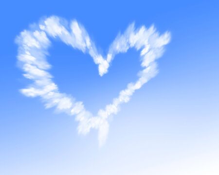 White heart shaped cloud trail in a blue skyの写真素材
