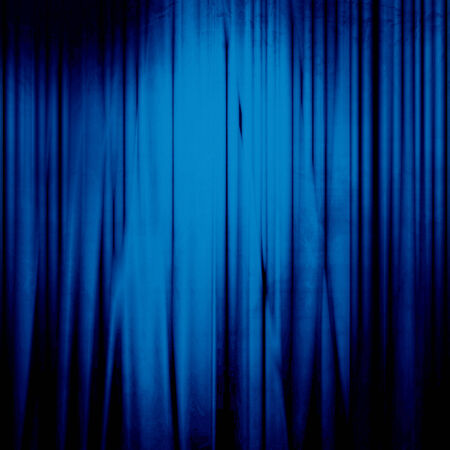 blue movie or theatre curtain with a bright spotlightの写真素材