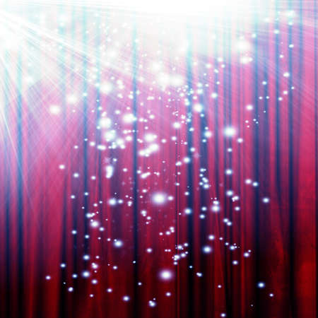 red movie or theater curtain with a bright spotlight with glitters and sparklesの写真素材