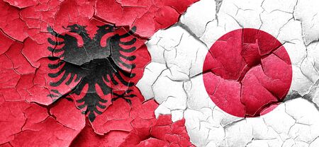 Albania flag with Japan flag on a grunge cracked wallの写真素材